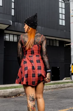 Vestido tipo overol en rolex sublimado con estampado de cuadros exclusivo de nuestra marca, escote en V, tiras graduables, cortes delanteros laterales en blonda rígida, bolsillos laterales, asimetría en largo delantero y cierre posterior. / Overall-style dress in sublimated rolex fabric with an exclusive checkered print from our brand, V-neckline, adjustable straps, side front cuts in rigid lace, side pockets, asymmetrical front length, and back closure.