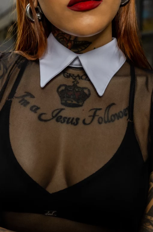 Blusón silueta amplia, en mallatex negra con cuello en rolex blanco. / Oversized blouse, in black mallatex with a white rolex collar.