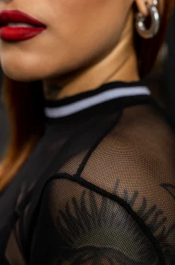 Buso en mallatex negro con silueta semi ajustada, manga larga con cuello y puños en rib de rayas blancas con negro.  / Black mallatex sweatshirt with a semi-fitted silhouette, long sleeves, and striped white and black ribbed collar and cuffs.