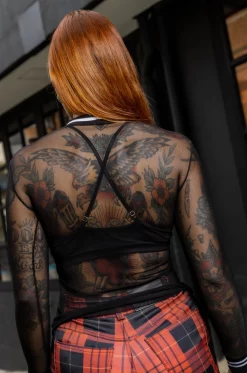 Croptop con silueta semi ajustada, en blonda grabada, mangas cortas, con cuello y puños en rib negro con blanco. / Semi-fitted croptop, in engraved lace, with short sleeves, and black with white ribbed neckline and cuffs.