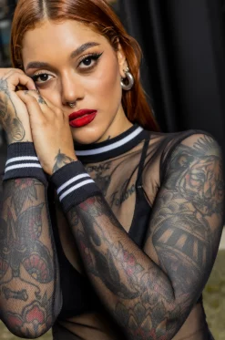 Croptop con silueta semi ajustada, en blonda grabada, mangas cortas, con cuello y puños en rib negro con blanco. / Semi-fitted croptop, in engraved lace, with short sleeves, and black with white ribbed neckline and cuffs.