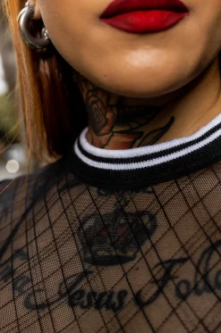 Croptop con silueta semi ajustada, en blonda grabada, mangas cortas, con cuello y puños en rib negro con blanco. / Semi-fitted croptop, in engraved lace, with short sleeves, and black with white ribbed neckline and cuffs.